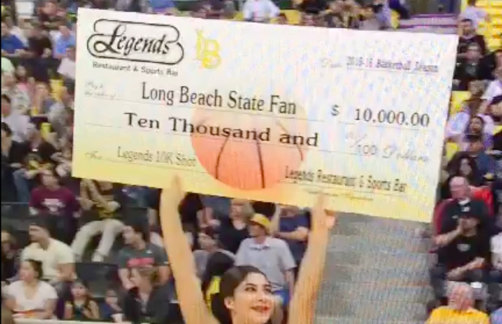 This image shows the posterboard sized 10,000 check offered to the Long Beach student that hit the half-time, half-court shot for the win.