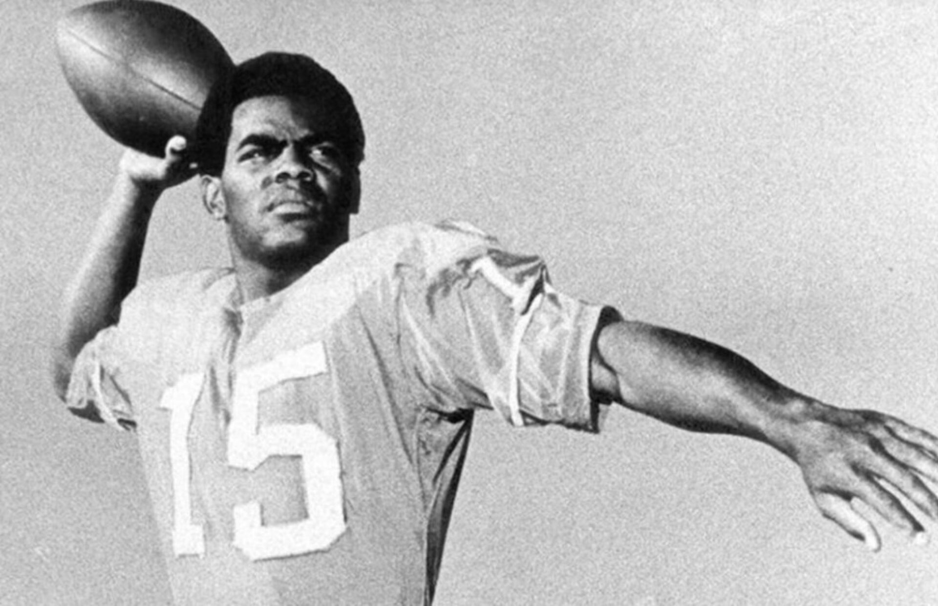 This image depicts Marlin Briscoe holding a football as he takes his pose for the NFL